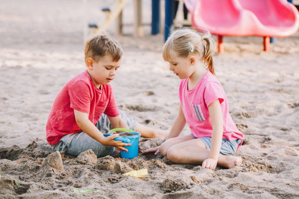 Two children playing in the sand