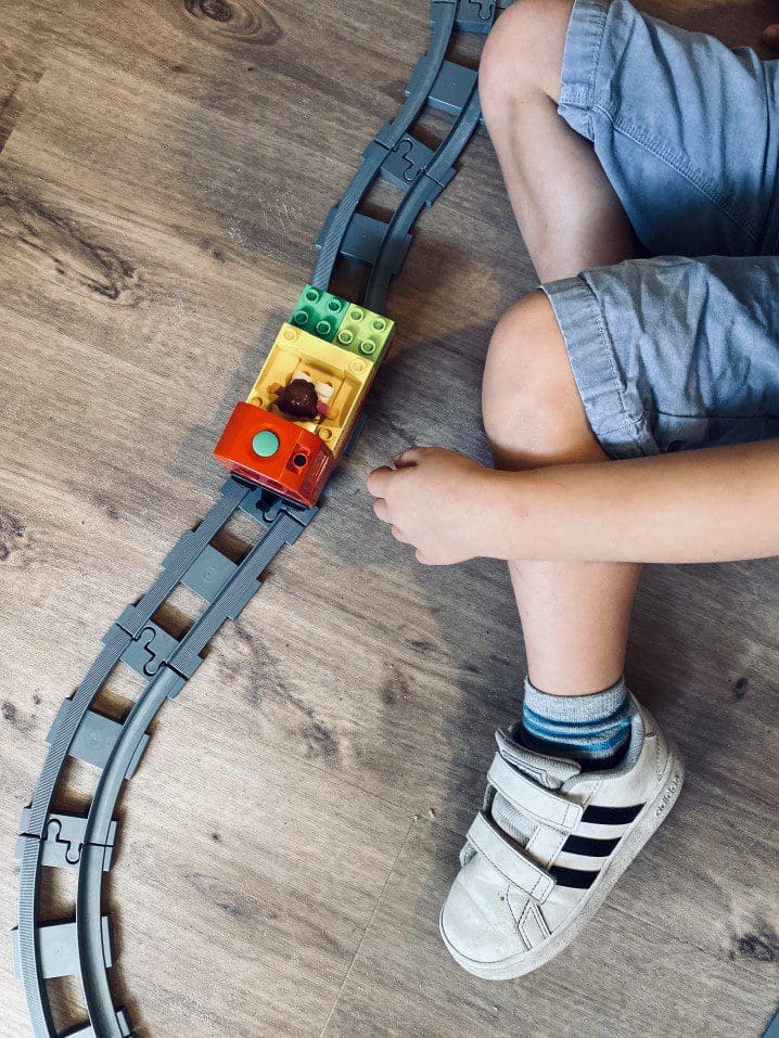 Child playing with toy train