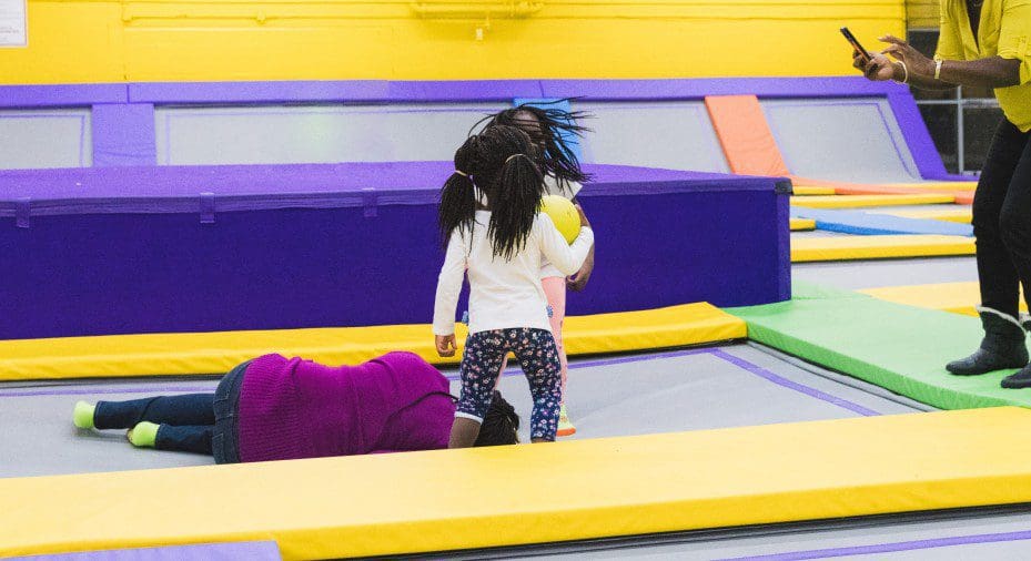 Kids playing on a trampoline.