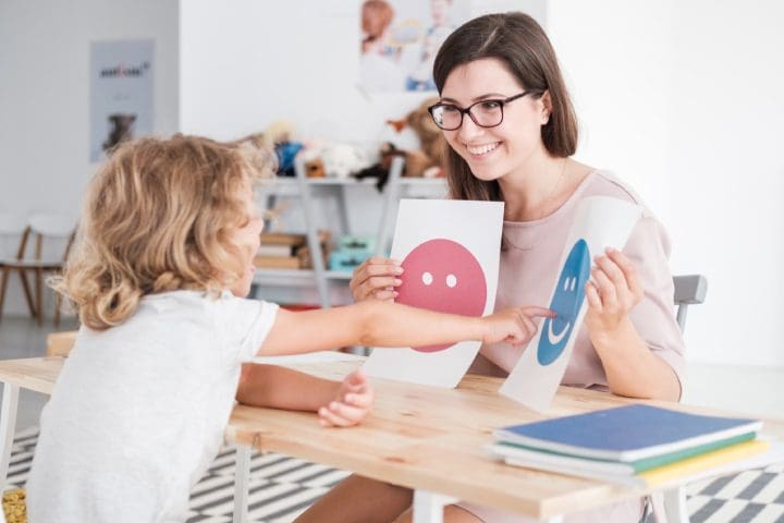 Parent teaching autistic child about emotions