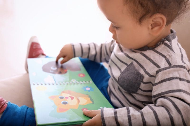 Young toddler boy looking through a book
